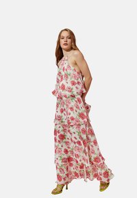 Maxikleid aus leichtem Material mit rosa Rosen auf weißem Hintergrund, geschichteter Gestaltung, Spaghettiträgern und Rüschendetails.