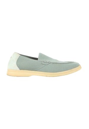 Mocassin slip-on vert clair avec semelle beige et détails en suède, conçu pour un usage décontracté.