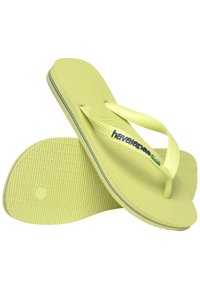 Šviesiai geltoni šlepetės su tekstūruotais padais ir dviejų tonų dirželiais. Su Havaianas logotipu ir daugiaspalviais apvadais palei padais kraštus.