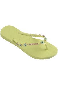 Light green rubber flip-flop with textured sole, decorative flowers, and metallic accents on the strap. Brand logo visible on footbed.
