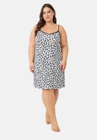 Nocna sukienka bez rękawów z białą bazą w czarne i niebieskie wzory w panterkę, wykonana z miękkiej tkaniny, długość do połowy uda, z regulowanymi ramiączkami.