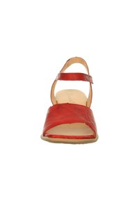 Rote Leder-Sandale mit offenem Zeh, Überkreuz-Design und Knöchelriemchen. Verfügt über eine flache, beige Sohle und eine glatte Textur.