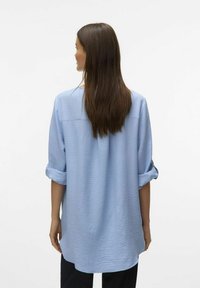 Lichtblauwe, lange mouw shirt gemaakt van gestructureerde stof met opgerolde manchetten en een losse pasvorm. De achteraanzicht toont een rechte zoomlijn.
