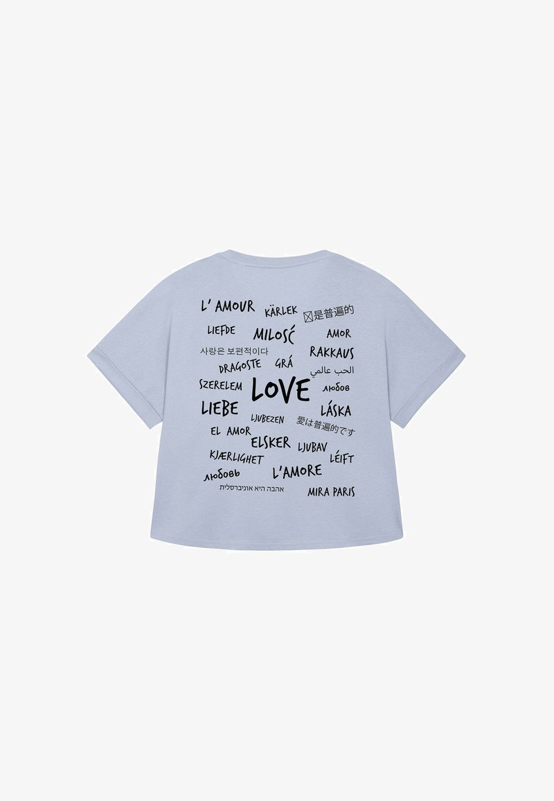 T-shirt bleu clair à manches courtes arborant le mot "AMOUR" ainsi que des traductions dans plusieurs langues, imprimées en noir avec des tailles de police variées.