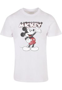 Balta medvilnė marškinėliai su Mikės Pūkuotuko grafika su juodais ir raudonais akcentais. Viršuje esantis tekstas sako "MICKY" ryškiomis raidėmis.