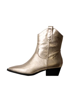 Cowboystøvle i metallisk guld læder med spids tå og lav sort hæl vist fra siden på hvid baggrund.