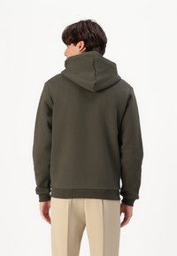 Oliven grøn hætte sweatshirt med afslappet pasform, ribbede mansjetter og kant; glat tekstur, synlige sømme og hætte detaljer.