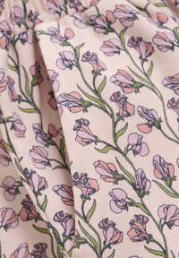 Blommönstrad tyg i ljusrosa med lila och gröna illustrationer av blommor, med en mjuk textur och ett veckat mönster.