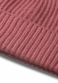 Beanie a costine in morbido knit di rosa profondo. Presenta strisce verticali testurizzate e una fascia strettamente intrecciata sul bordo.