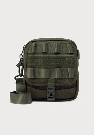 Kompakt skulderveske i olivengrønt fra Carhartt med justerbar stropp, frontspenne og webbingløkker for feste.