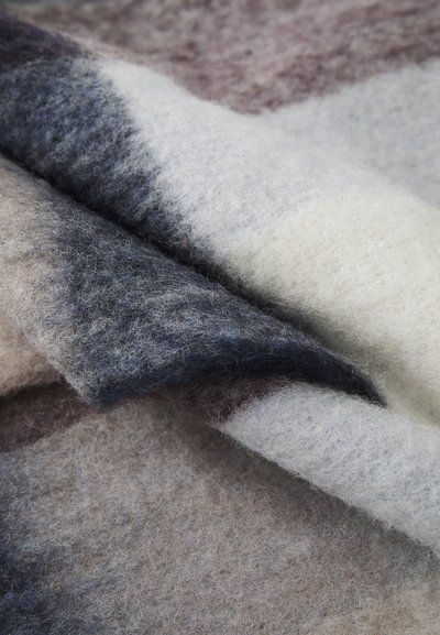 Wool blend throw with soft texture, featuring shades of gray, cream, and burgundy in a flowing pattern. Edges are lightly frayed.