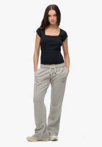 Black fitted t-shirt with lace trim and short sleeves, paired with light grey sweatpants featuring a logo and drawstring waist.