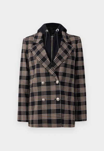 Fekete és fehér kockás, dupla gombos blézer ezüst gombokkal és fekete kapucnival a belső részén. Kiemelkedő reverekkel és strukturált szabással rendelkezik.