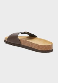 Sandali in pelle marrone con una fascia larga e fibbia regolabile, soletta in sughero, suola testurizzata e interno marrone chiaro.