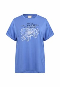Světle modré tričko s krátkým rukávem a kulatým výstřihem, s bílou květinovou grafikou a textem "PAS DE JACINTHES SANS PLUIE." Hladká textura.