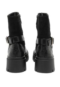 Stivaletti neri alla caviglia con tomaia in suede, tacco in pelle stampata, dettaglio con fibbia e suola in gomma spessa progettata per stabilità e stile.