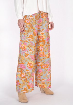 Brede bloemenbroek in grijze stof met roze en oranje bloemenpatronen. Beschikt over een gladde textuur en een losse pasvorm, gecombineerd met beige haklaarzen.