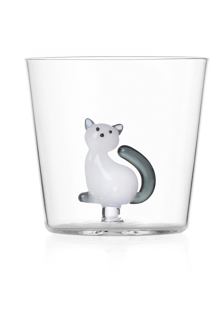 Tazza di vetro trasparente con figurina di un gatto bianco con coda e orecchie grigie, superficie liscia e forma arrotondata.
