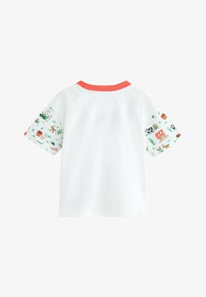 Bijela majica s koraljnim ovratnikom i uzorkovanim kratkim rukavima s ilustracijama životinja i kaktusa na svijetloj pozadini.