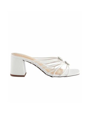 White heeled sandal with block heel, multiple thin straps, and two circular rhinestone embellishments on the upper front.