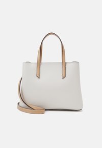 Borsa tote bianca con manici marroni chiari e tracolla staccabile coordinata su sfondo bianco.