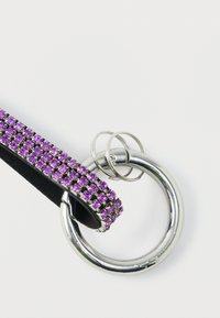 Purple crystal-embellished band attached to a silver metal ring, featuring a smooth texture and round shape, secured with two small rings.