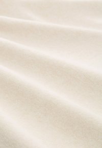 Cremefarbener Stoff mit einer weichen, glatten Textur, der ein dezentes diagonales Muster und einen leichten Glanz aufweist. Falten und Drapierungen sind sichtbar.