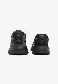 Black athletic shoes made of mesh and synthetic materials. Features padded collar, lace-up design, and textured rubber sole.