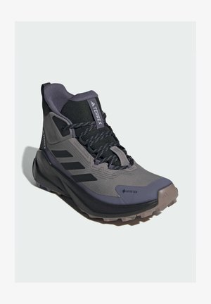 Grijze en zwarte mid-cut wandelschoen met Gore-Tex-materiaal, gestructureerde bovenkant, verstevigde neuskap en robuuste zool met grippatronen.