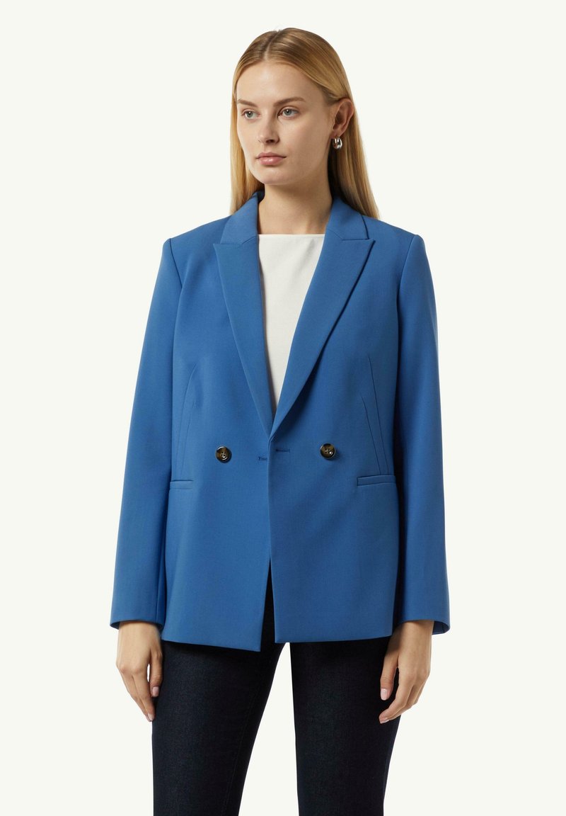 Blauwe dubbelbreasted blazer gemaakt van gladde stof, met een gelapte revers, twee voorzakken en zwarte knopen.