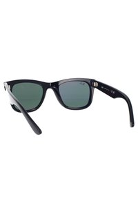 Occhiali da sole in plastica nera con lenti verde scuro. Design squadrato con aste dritte. Marchio evidente all'interno dell'asta. Finitura pulita.