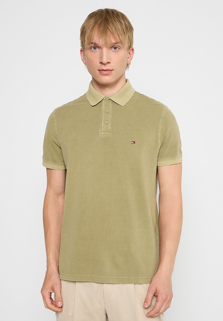 Polo de color verde oliva hecho de algodón, con un cuello clásico, tapeta de tres botones y un pequeño logo bordado en el pecho.