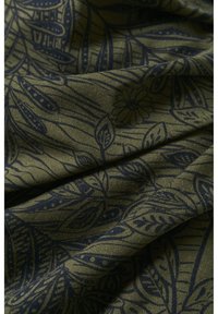 Tissu vert avec un motif botanique bleu foncé comprenant des feuilles et des fleurs, présenté avec des plis doux et des détails de texture.