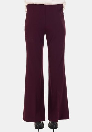 Pantaloni larghi bordeaux realizzati in tessuto morbido, con una vestibilità sartoriale e cuciture verticali, abbinati a scarpe con tacco nere.