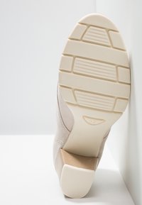 Scarpa con tacco beige con tomaia testurizzata, suola in gomma con profonde scanalature e tacco impilato marrone. Taglia contrassegnata come 37.