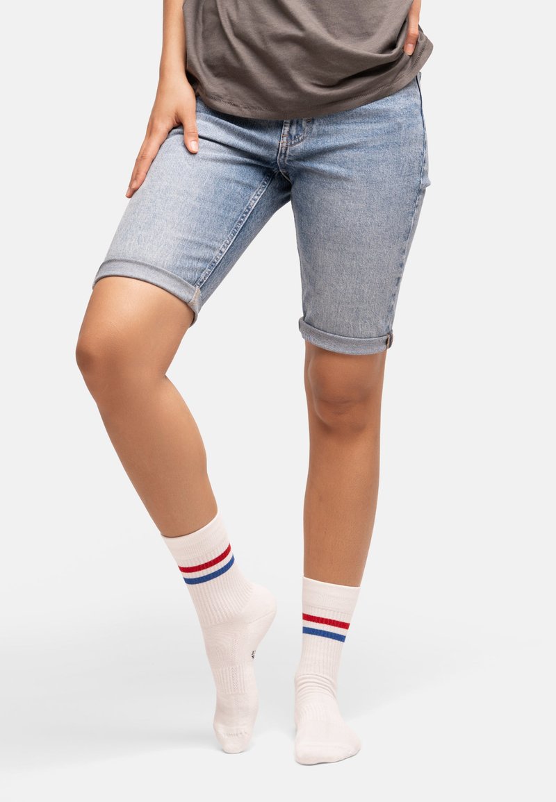 Jeansshorts i ljusblått med upplagda nederkant, i kombination med vita strumpor med röda och blå ränder. Avslappnad och bekväm design.