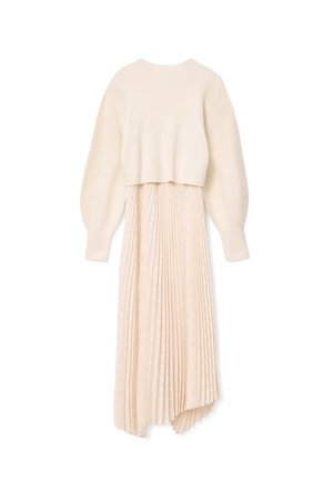 Completo due pezzi composto da un maglione a coste di colore crema e una lunga gonna plissettata in una tonalità beige chiaro con un sottile motivo di texture.