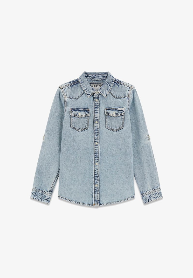 Chemise en denim bleu clair avec deux poches poitrine, un col pointu et une patte de boutonnage devant. Présente des coutures visibles et des détails aux poignets.