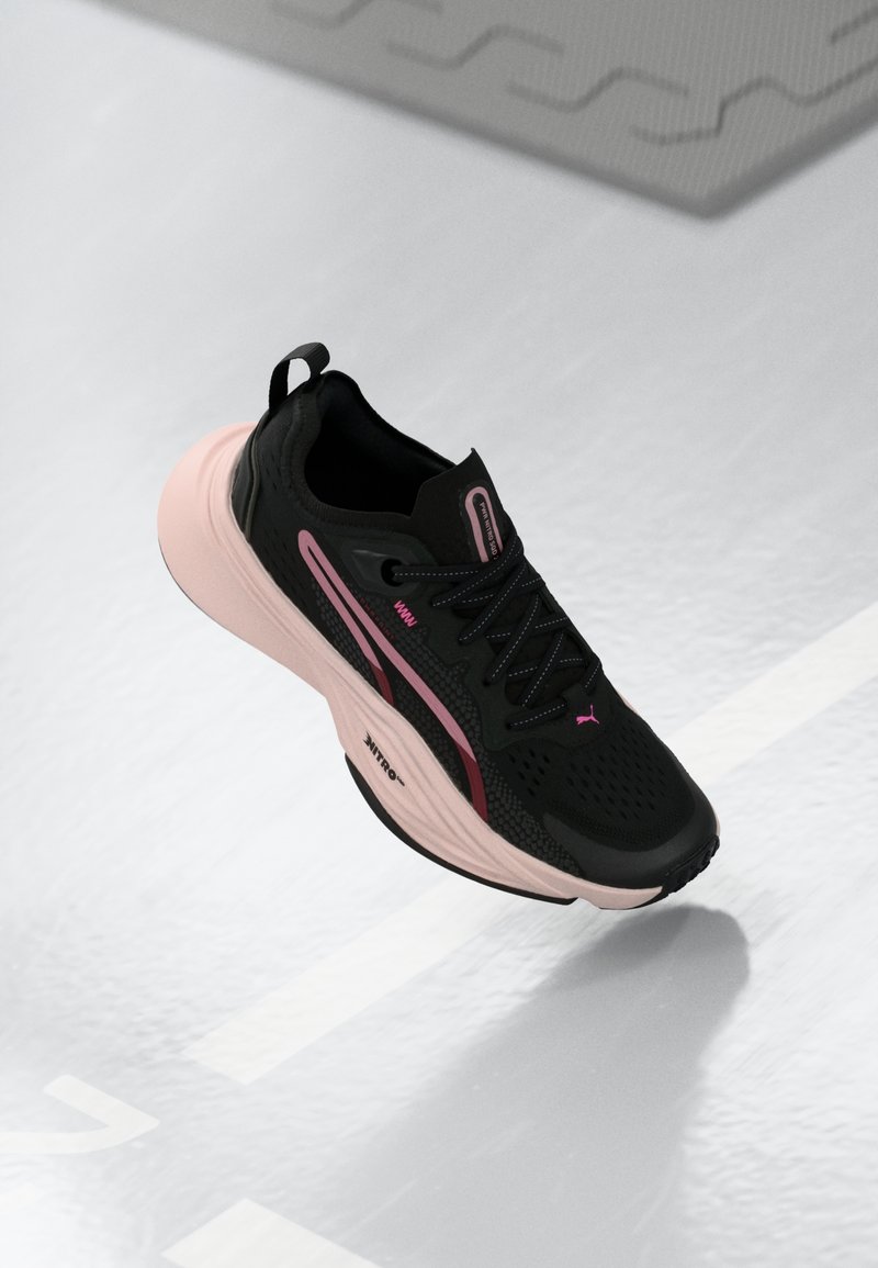 Czarne buty sportowe z różowymi akcentami i teksturowaną cholewką. Posiadają amortyzowaną różową podeszwę i czarne sznurówki. Lekka konstrukcja zapewniająca wydajność.