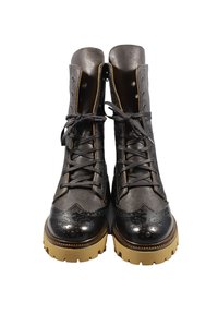 Stivaletti alla caviglia in pelle nera con design brogue, punta tonda e suola in gomma. Presentano chiusura con lacci e occhielli metallici per garantire durata.