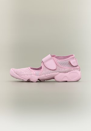 Chaussure de sport rose avec tige en mesh respirant, brides réglables en velcro sur le coup de pied et le talon, et semelle coussinée, vue de profil.