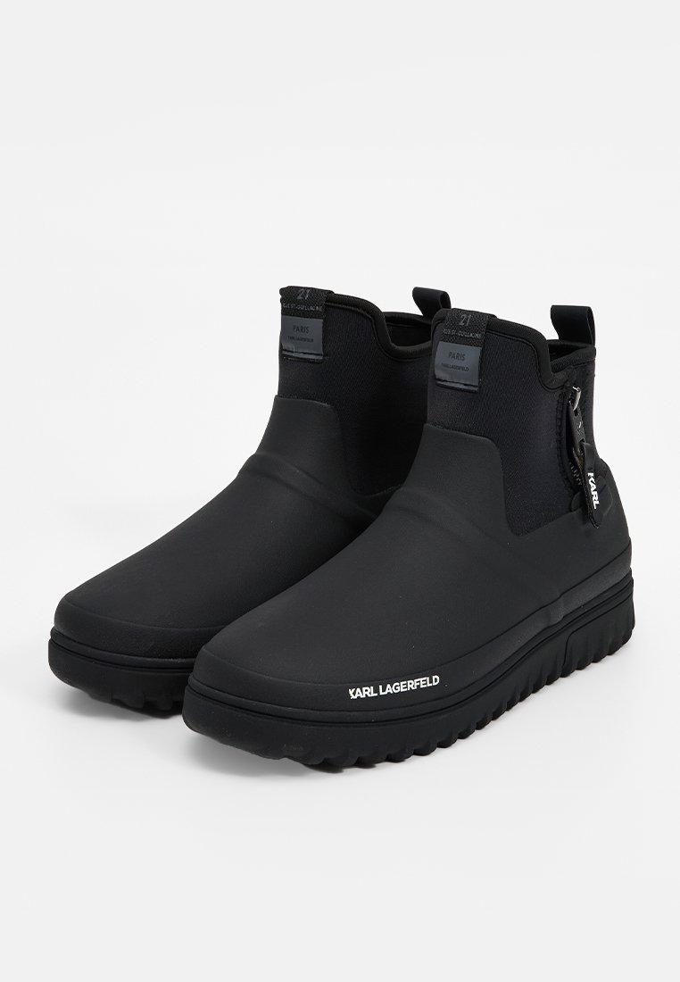 Czarne wodoodporne botki za kostkę wykonane z materiału gumowanego, z teksturowanym wierzchem, detalem zamka błyskawicznego oraz grubą, żłobioną podeszwą.