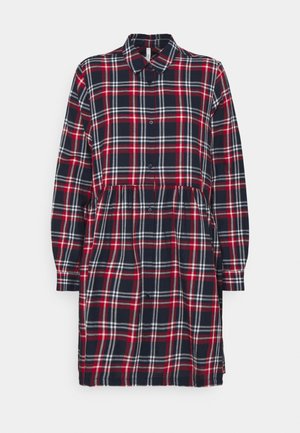 Abito a quadri nei colori blu navy, rosso e bianco. Maniche lunghe con polsini a bottone, colletto e vita arricciata. Realizzato in tessuto morbido, lunghezza al ginocchio.