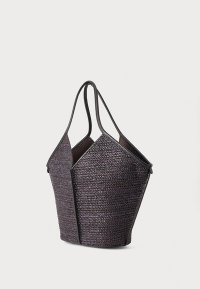 Sac cabas tissé gris foncé avec deux poignées et une forme structurée, géométrique sur un fond clair uni.