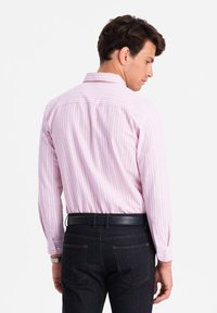 Roze en witte gestreepte shirt met lange mouwen, knoopmanchetten en een klassieke kraag, gecombineerd met donkere spijkerbroek.