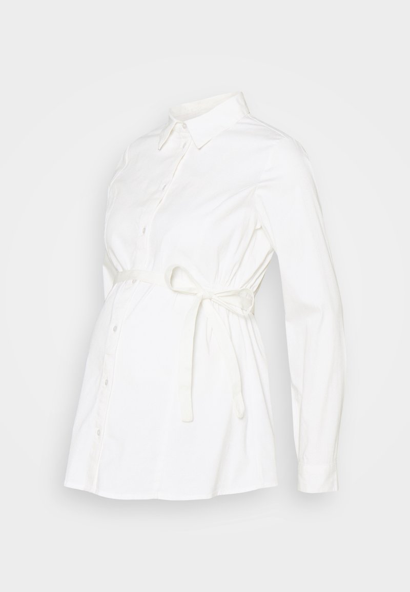 Chemisier de maternité blanc avec un front boutonné, des manches longues et une taille à nouer pour un ajustement réglable. Fabriqué en tissu doux avec une texture lisse.