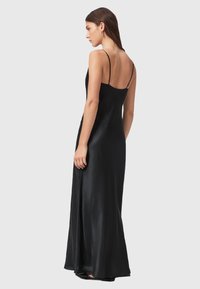 Abito maxi in satin nero con una texture liscia, spalline sottili e uno spacco alto. Presenta un corpetto aderente e una gonna fluida.