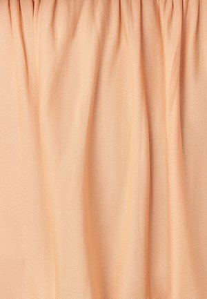 Tkanina breskvaste boje s mekom, glatkom teksturom, koja ima nježne nabore i suptilan sjaj. Pogodna za odjeću ili mekane dekoracije.