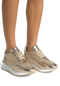 Sneakers metallici dorati con accenti luccicanti di strass, lati in mesh testurizzato e suola in gomma bianca. Design con lacci e dettaglio del logo.