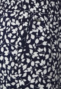 Námořnická látka se vzorem bílého listí, s elastickým pasem a malou značkovou štítkou na boku. Texturovaný, lehký materiál.